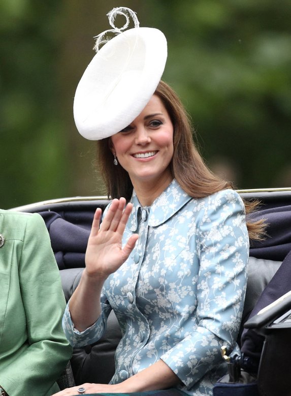 Kate sfila in corteo sulla carrozza verso Buckingham Palace. Quest'anno ha indossato un cappotto Catherine Hooker celeste, a fiori bianchi, elegante ma un oò severo, e un cappello bianco Lock & Co.