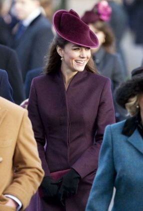 il cappotto è lo stesso dell'immagine precedente, ma portato senza cintura. Il cappello è Jane Corbett, e sotto al cappotto Kate indossa un abito nero, calze nere e scarpe nere Mascaro.