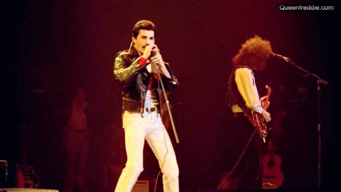 Freddie Mercury apre le danze con giacca di pelle, pantaloni bianchi attillati e una t-shirt con in logo di superman!