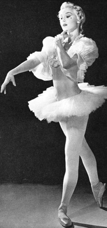 in questa scena del film Audrey danza vestita di tutto punto come una ballerina, con tutù e scarpe da punta, e con una parrucca e un neo finto che danno al look un sapore Settecentesco