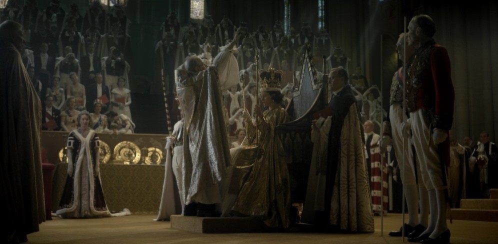 Un'altra grandiosa scena ricreata nei minimi dettagli nella serie è quella dell'Incoronazione di Elisabetta, che indossa un abito candido e viene poi ammantata con una veste dorata
