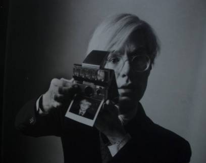 Warhol mentre si autotrae con la polaroid.