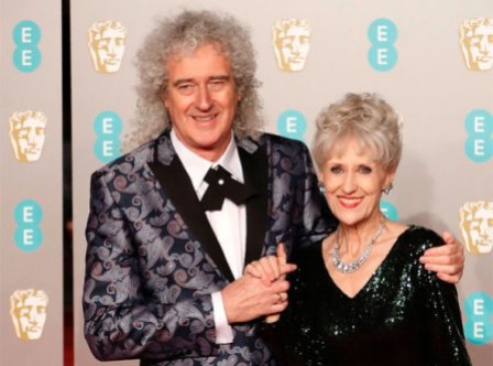 Brian May in giacca di broccato con Anita Dobson